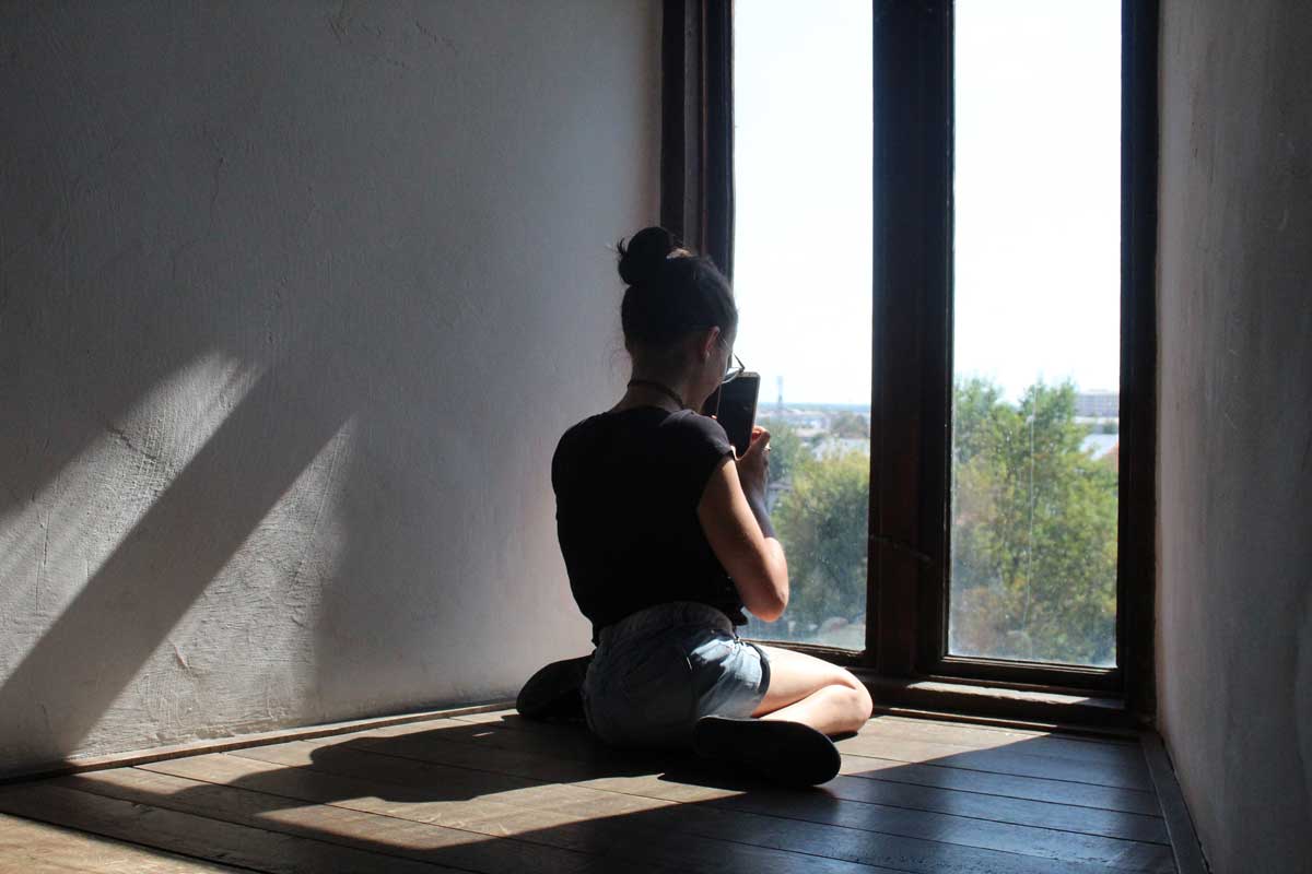 girl in front of window on phone