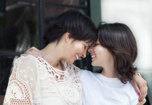 mother and daughter smile and hug each other