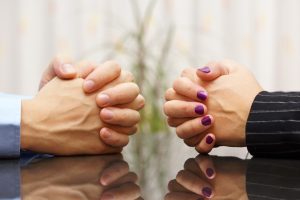 tense couple with hands clasped